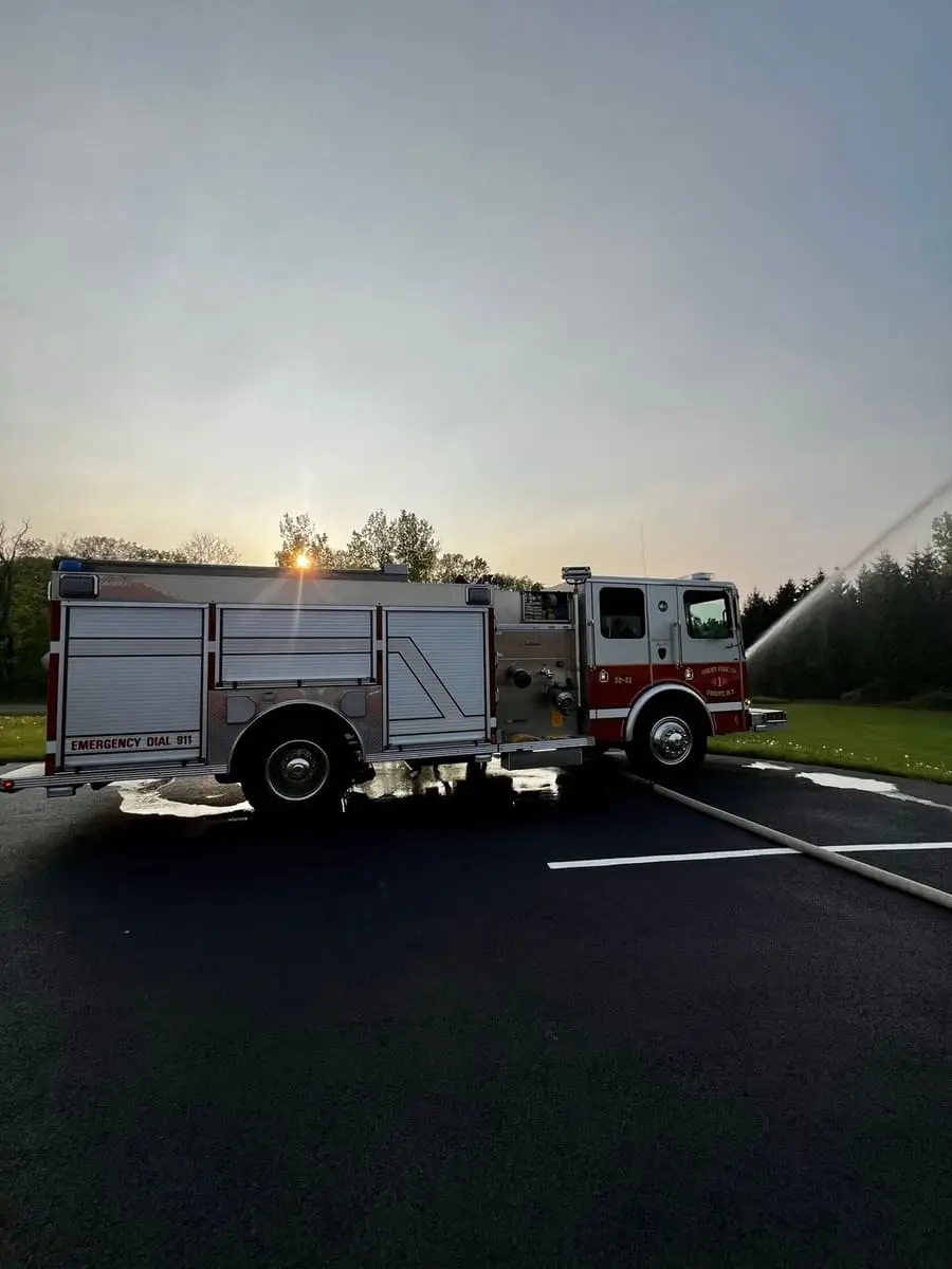 Engine 22-22 Master Stream at Dusk — Flowing the top-mounted deck gun master stream outside Station 1 during an evening pump drill.