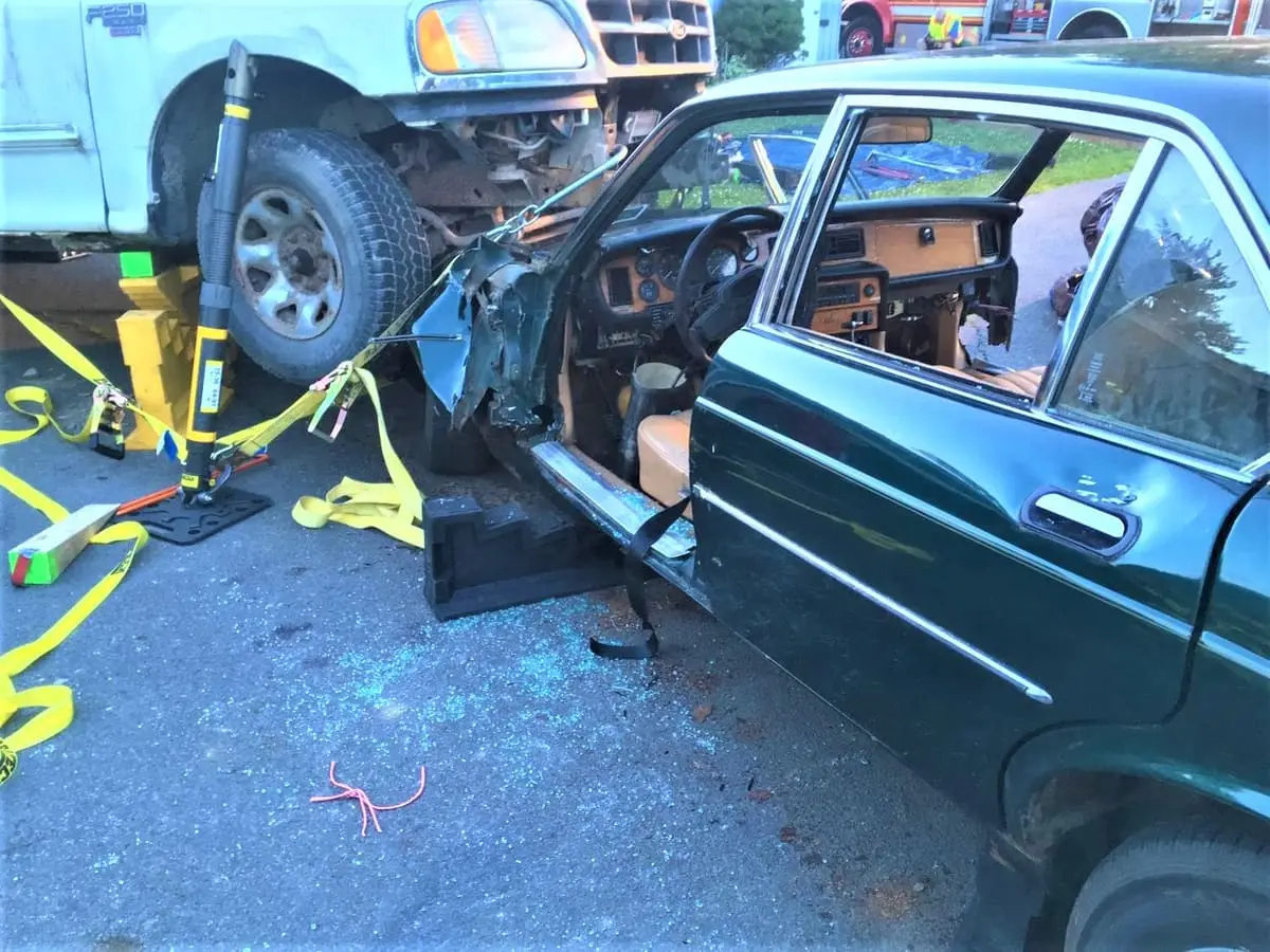 Hands-On Auto Extrication — Crews working side by side with hydraulic cutters and cribbing on a training vehicle.