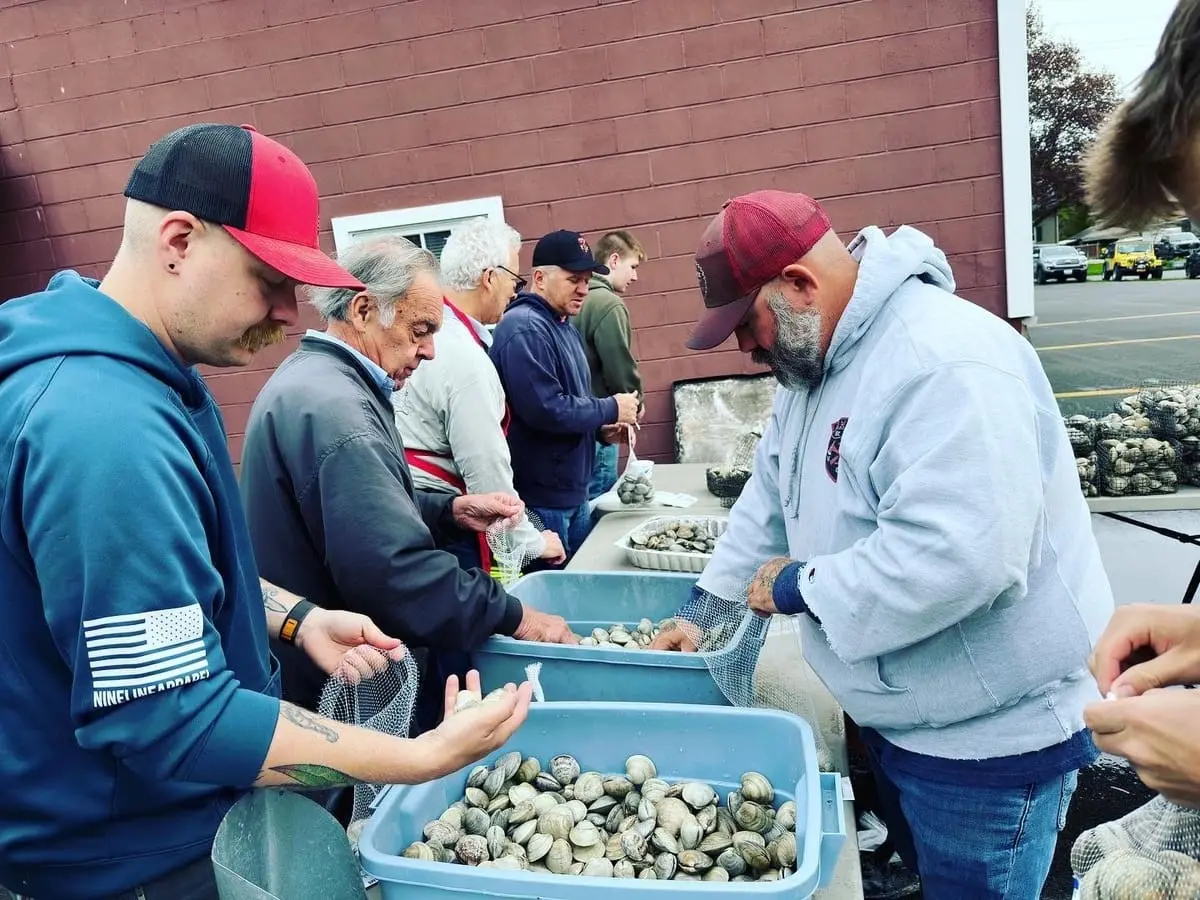 Ghent volunteers preparing fresh clams for the annual fire company clambake