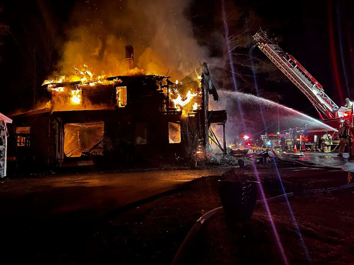 Ghent firefighters advancing hoselines at a nighttime structure fire