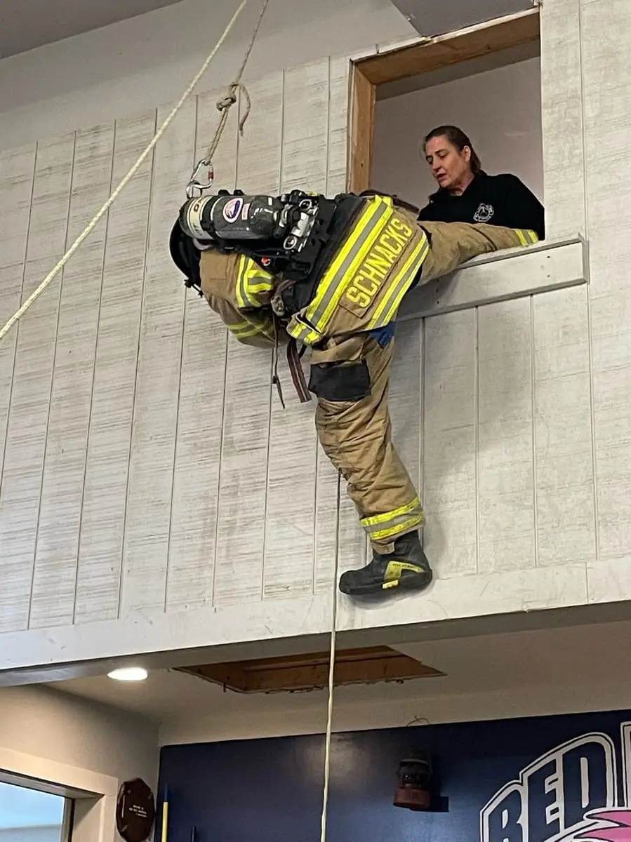 Emergency Window Bailout Drill — Firefighter survival training: deploying a personal bailout harness from an upper-floor window prop.